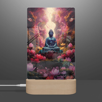 Lamp buddha sitting before lots of flowers