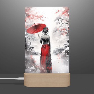 Lamp snowy landscape with a woman holding an umbrella